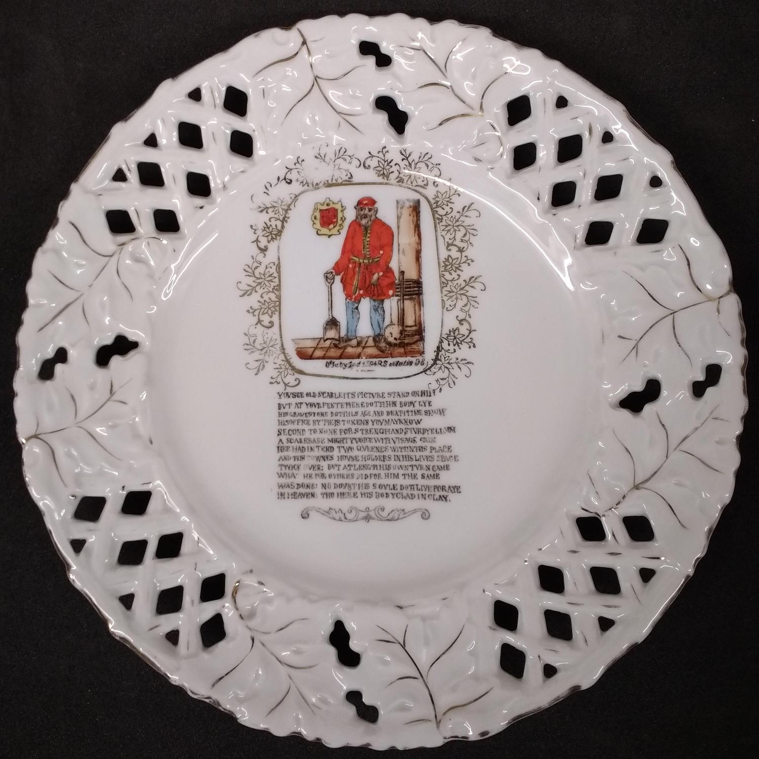  An ornamental china ribbon plate with a transfer print of Old Scarlett, the infamous grave digger. The image is printed in reds, yellows and browns and the plate has diamond shaped pierced edges and a leaf design in gold.