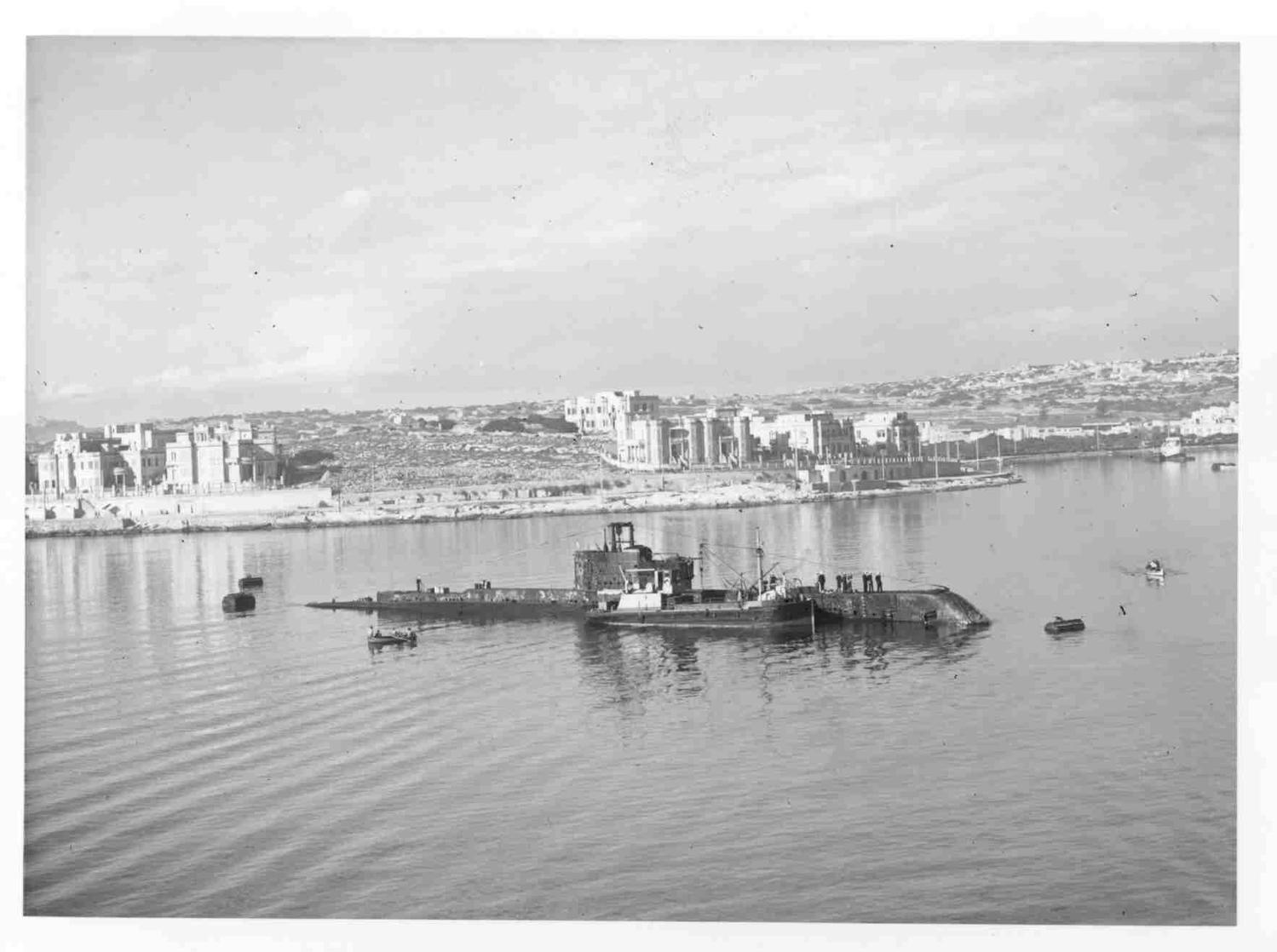HMSM OLYMPUS taking in supplies in Manoel Creek, Grand Harbour, Malta.  A 6928. Imperial War Museums. Part of the Admiralty Official Collection.