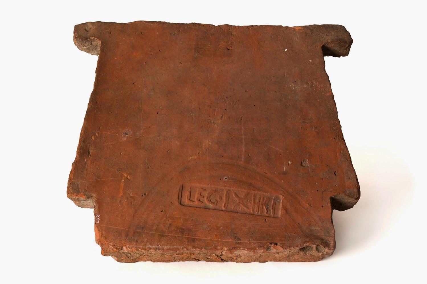 Ceramic tile "Armchair Voussoir type 3b". Use in the construction of vaulted ceilings. Stamped LEG.IX HISP. Discovered at Hilly Wood, Bainton in 1867. PETMG:L42A. Image: Peterborough Museum and Art Gallery