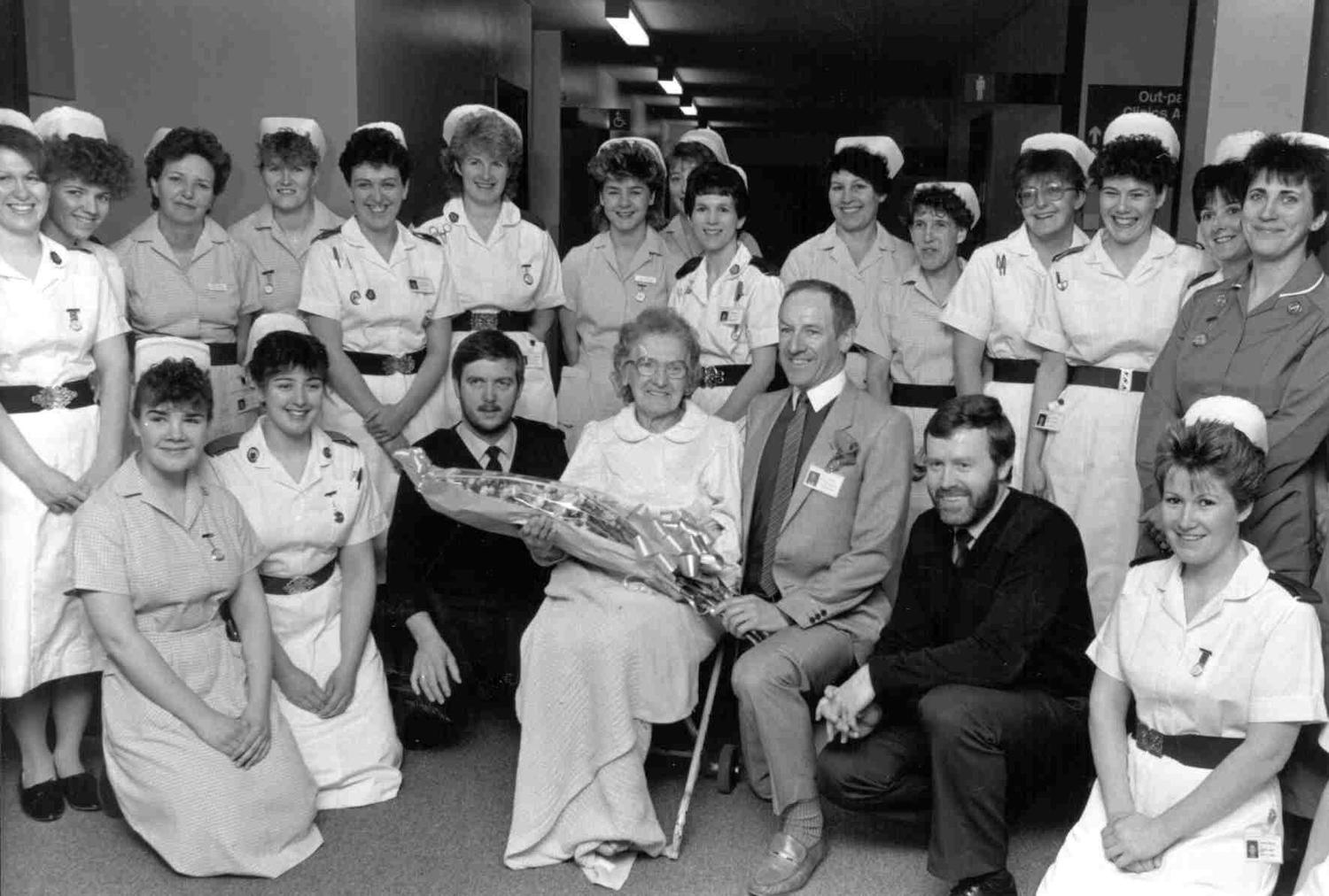 The first patient to use the newly opened Edith Cavell Hospital in Bretton, Florence Aldridge,  is shown with members of the nursing staff and the Chairman of the Health Authority, Tony Gibson, April 1988.